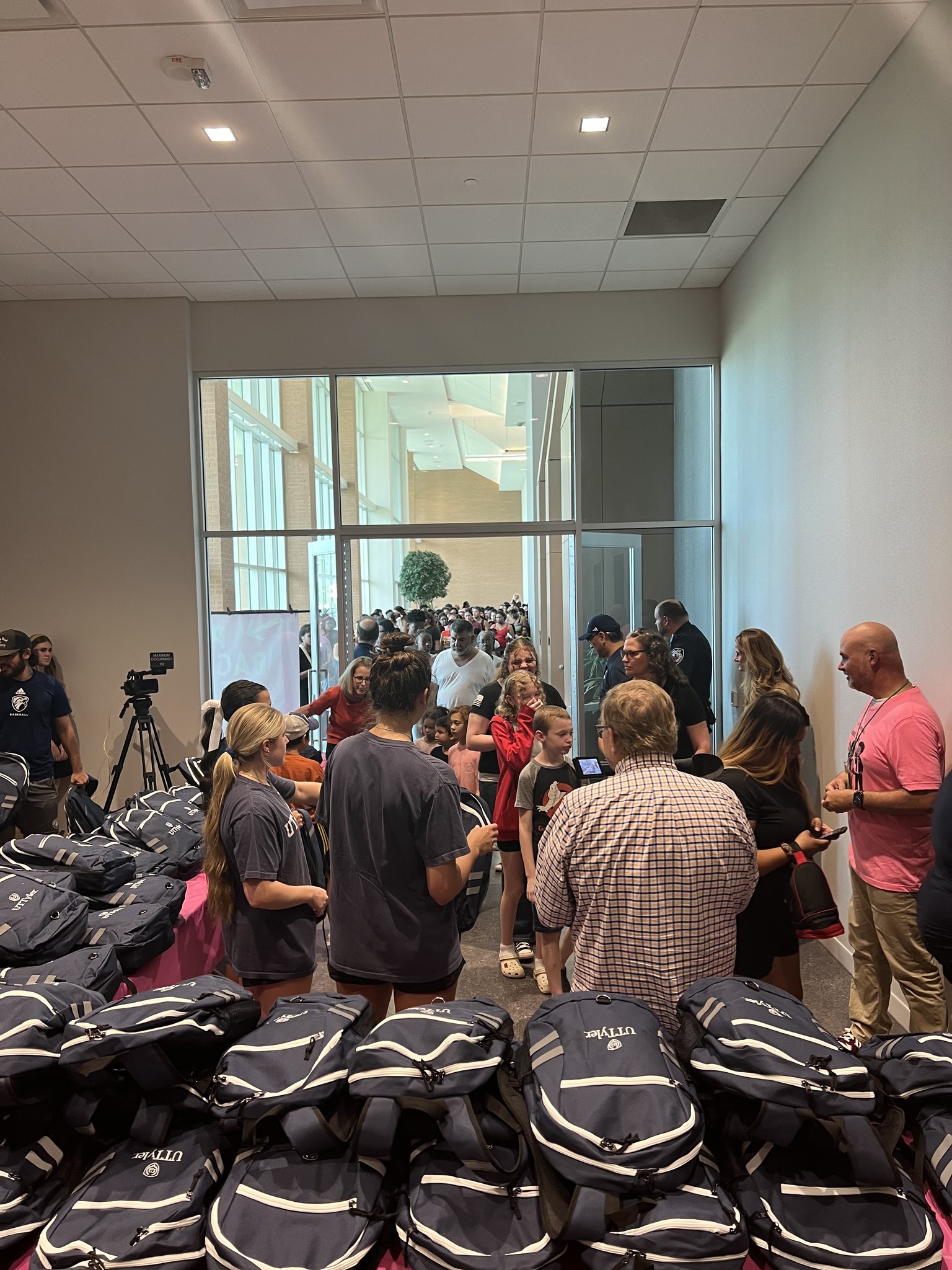 A room full of backpacks and people for the 2024 #SchoolIsCool event in Tyler, Texas.