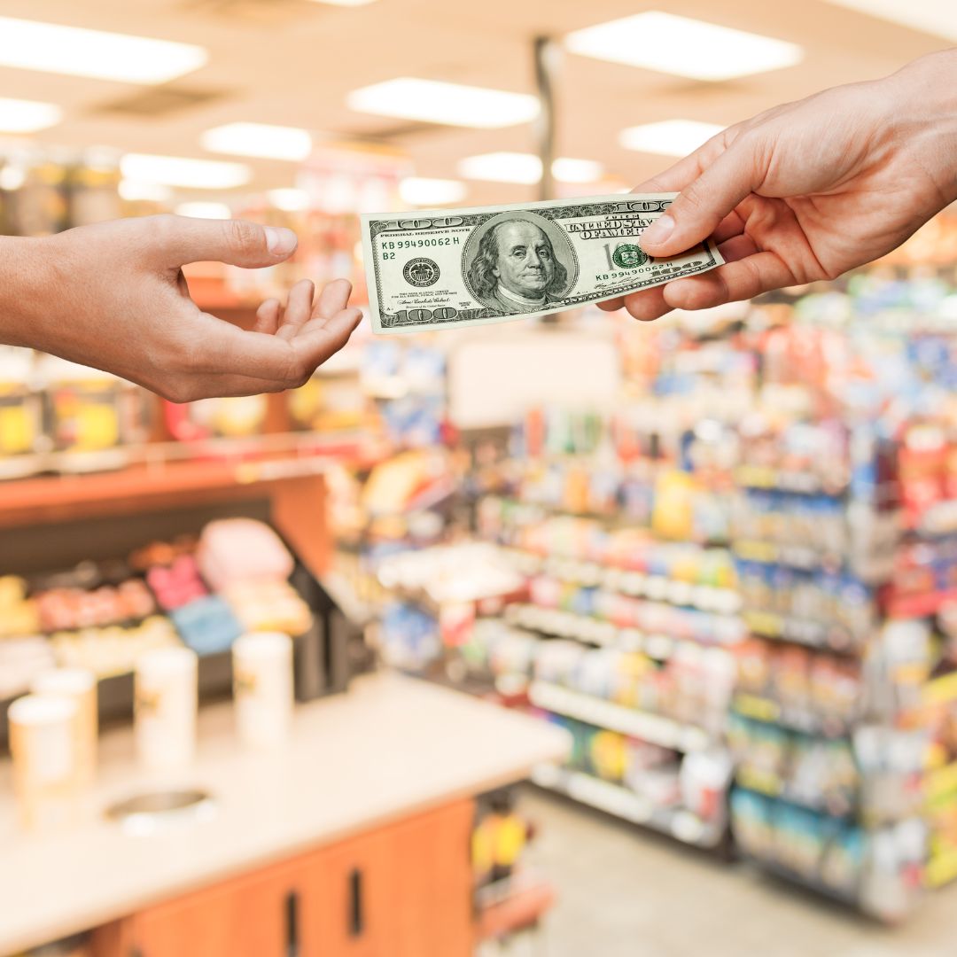 Hands exchanging cash inside store